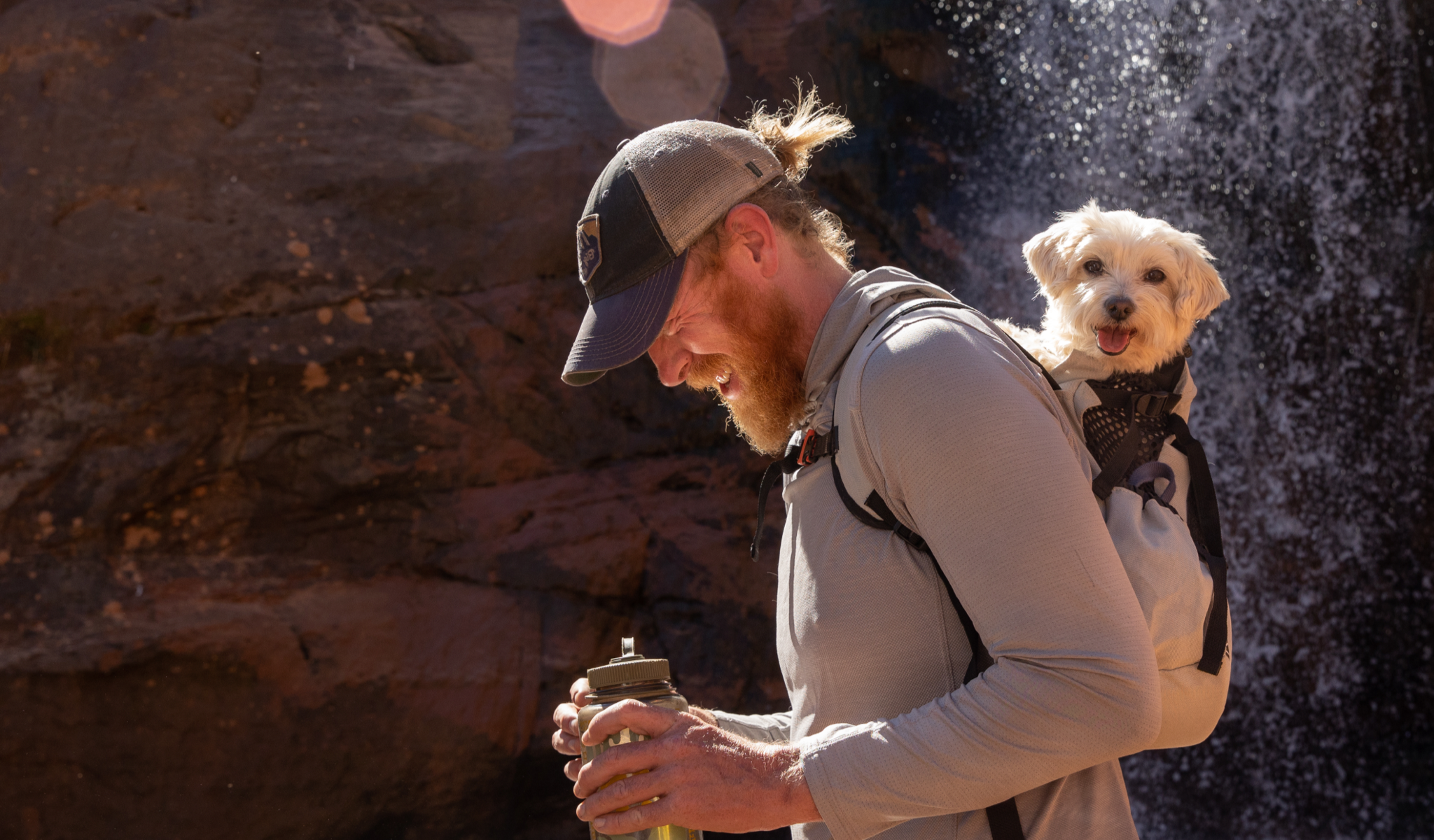 A man enjoys a hike with his dog in an AIR 2 backpack carrier