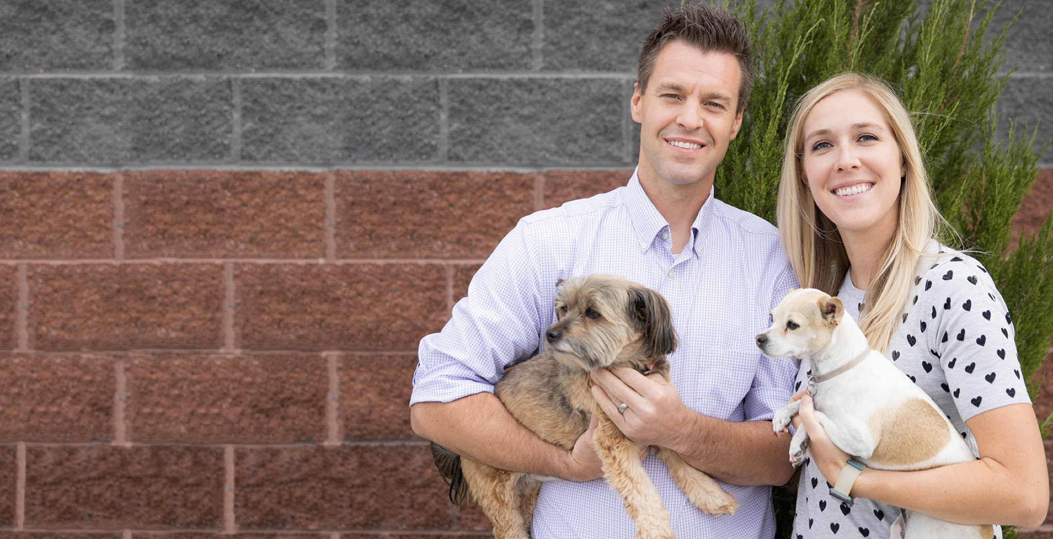 Joseph and Jen, the creators of the K9 Sport Sack backpack carrier, hold their rescue dogs